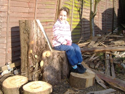 Sitting on a tree stump.